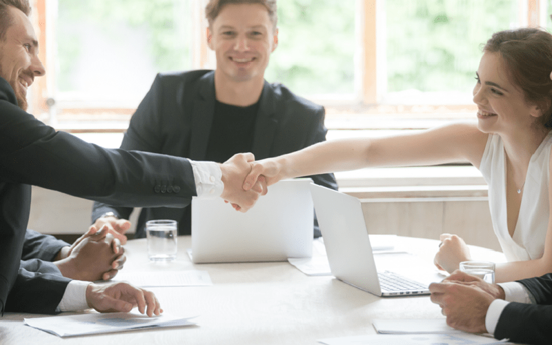 A imagem mostra um grupo de pessoas sentadas ao redor de uma mesa conversando animadas sobre carreira e plano de sucessão.