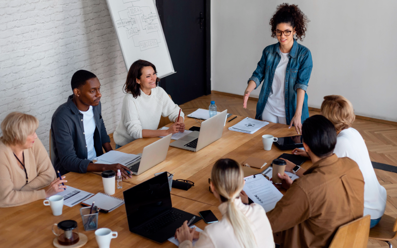 A imagem mostra um grupo de pessoas diversas conversando sobre como potencializar talentos na empresa em que trabalham.