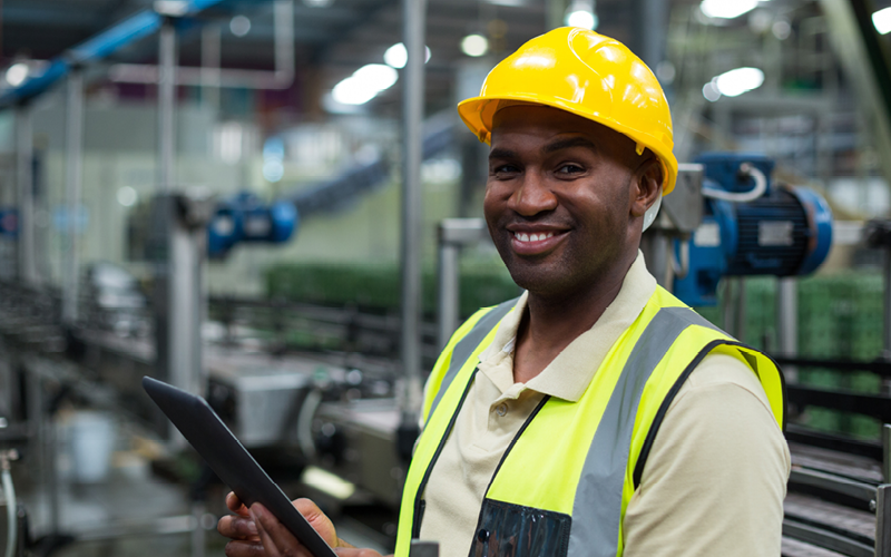 A imagem mostra um homem sorridente, utilizando equipamentos de proteção. A imagem busca representar como a satisfação dos funcionários pode afetar a produtividade na empresa.