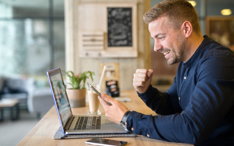 Homem com cabelos parcialmente grisalhos utilizando o computador. A imagem representa o uso da tecnologia no RH.