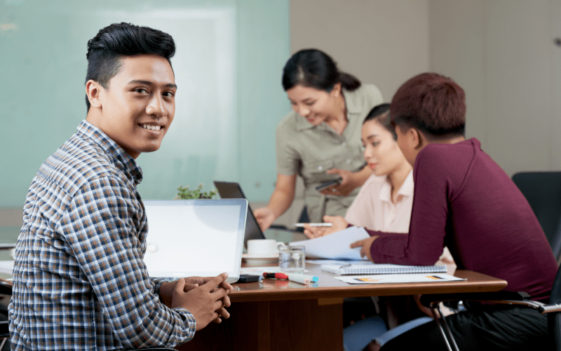 estagiários e trainees conversando em uma mesa de estudos.