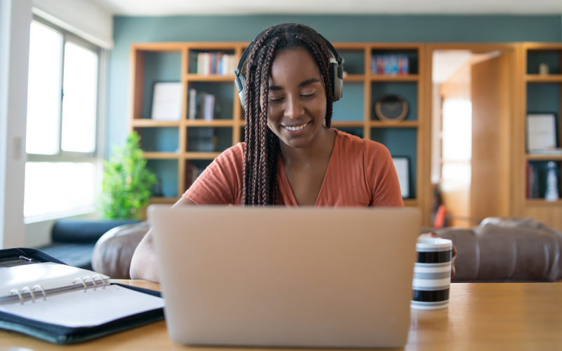 A imagem mostra uma mulher negra estudando em um notebook as diferenças entre gestão de performance e avaliação de desempenho.