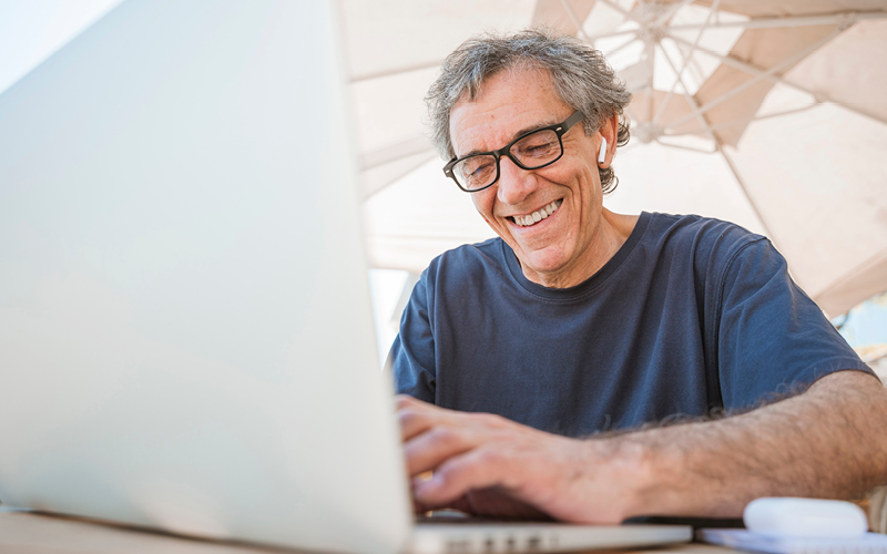 A imagem mostra um homem trabalhando sorrindo e animado, refletindo sua felicidade no trabalho.