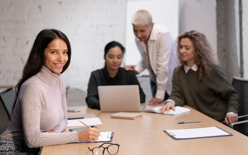 Quatro funcionários em uma mesa de escritório discutindo o que é EVP e como impacta na empresa onde trabalham.