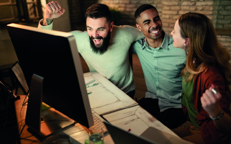 Três profissionais comemorando o sucesso de um teste de fit cultural realizado na equipe de trabalho.