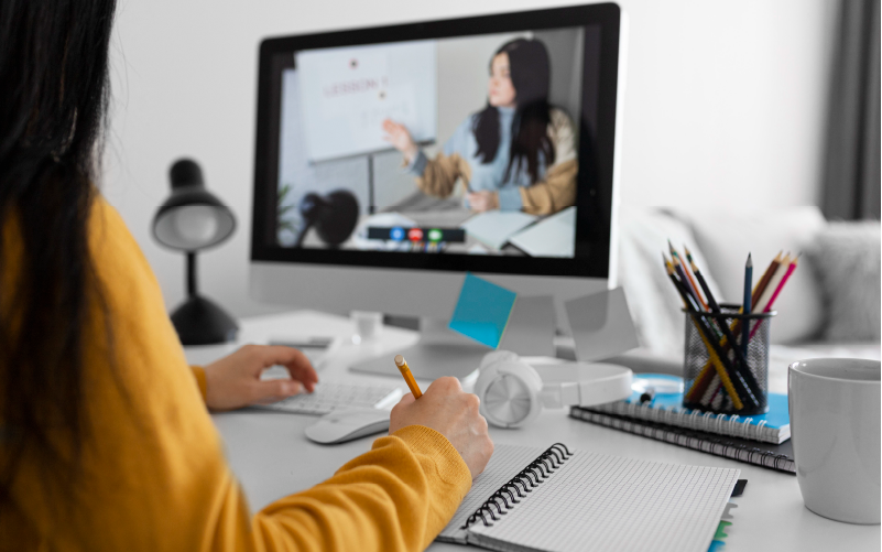 Mulher assistindo pelo computador uma apresentação usada como parte da estratégia de microlearning de um programa de desenvolvimento.