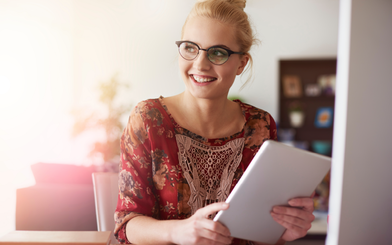 Mulher sorrindo ao conseguir fazer um uso equilibrado da tecnologia no trabalho em seu dia a dia.