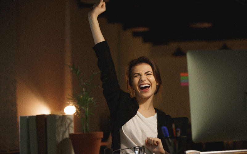 Mulher feliz por ter encontrado motivação no trabalho que realiza diariamente.