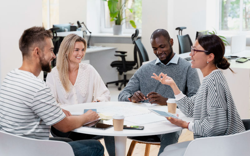 grupo de 4 pessoas diversas conversando sobre as melhores práticas de gestão de conflitos nas empresas