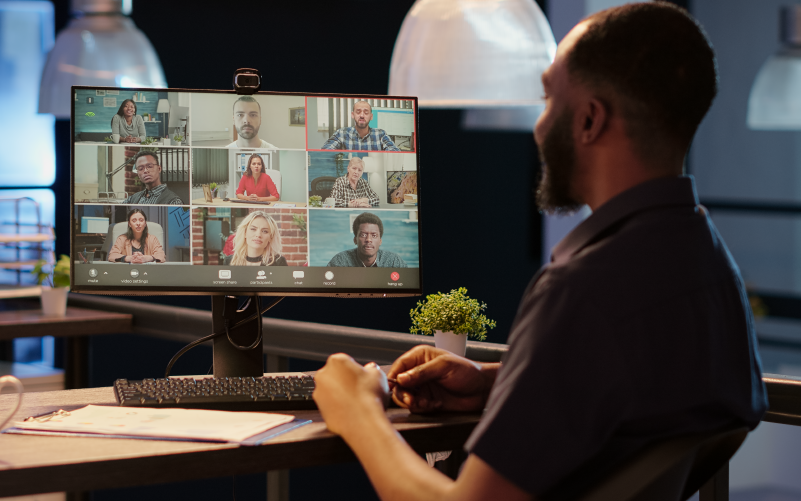 Homem com barba sentado em frente ao computador ligado em uma vídeochamada para representar o e-learning