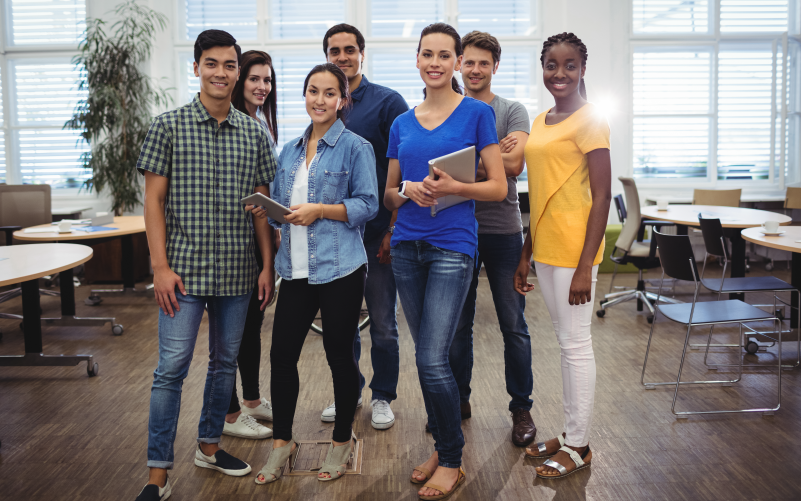 Imagem de capa para blog post sobre gestão de talentos. Na foto, temos um grupo de sete pessoas diversas. Elas estão felizes e se mostram confiantes.