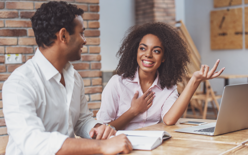 Imagem de capa de blog post sobre feedback contínuo. Na foto, observamos uma mulher e um homem negros conversando.