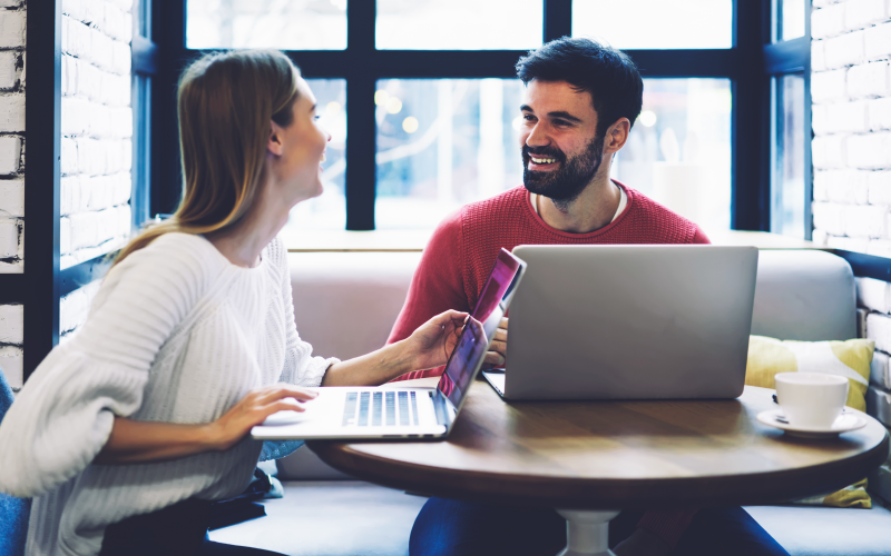 Imagem de capa para blog post que explica sobre feedback para estagiário. Na foto, observa-se um homem e uma mulher jovens conversando em uma reunião no trabalho.