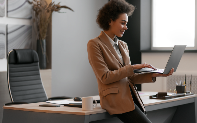 Imagem de capa para blog que aborda a importância estratégica do recrutamento data driven no RH. Na foto, observa-se uma mulher jovem e negra trabalhando em um notebook em um escritório.