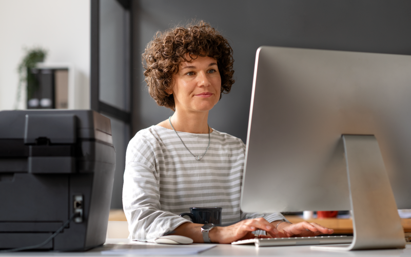 Mulher olhando para computador no trabalho, simbolizando o RH 5.0 e a evolução da gestão de pessoas