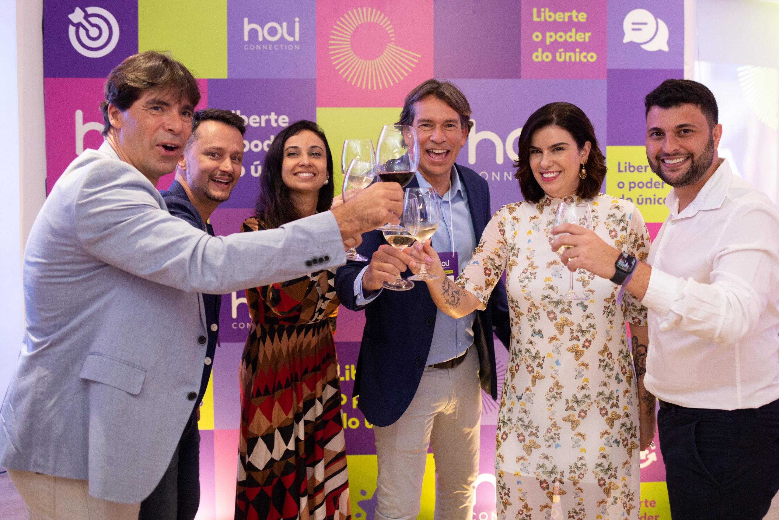 Equipe da Holi Connection brindando e sorrindo no evento de lançamento da startup