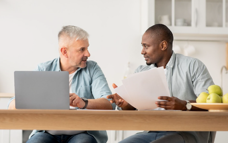 Capa para post blog. O conteúdo aborda dicas para que a gestão possa lidar melhor com o conflito de gerações no ambiente de trabalho. Na foto, observa-se dois homens, de idades diferentes, conversando sobre trabalho.