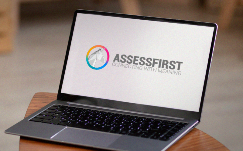 Notebook aberto exibindo a plataforma AssessFirst, ferramenta de assessment para recrutamento e gestão de talentos.